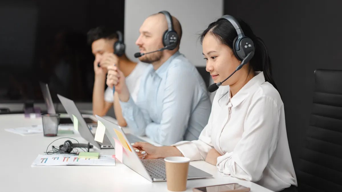 Best live chat tools for SaaS websites and onboarding flows support agents working at laptops with headsets