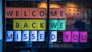 Window sign saying welcome back we missed you