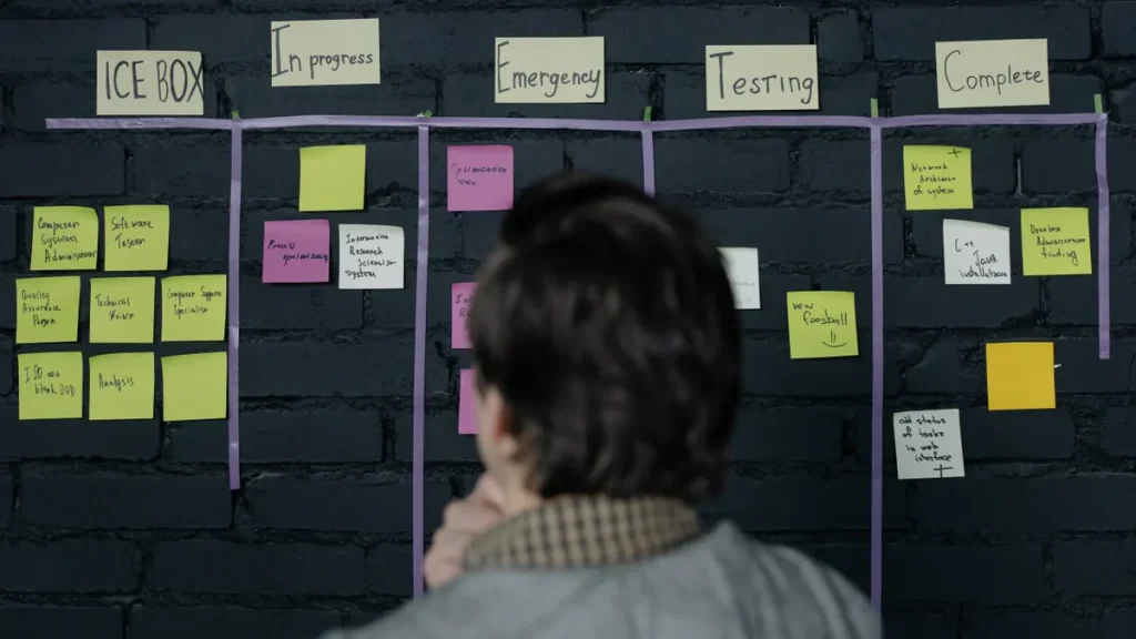 person viewing a project board covered with sticky notes