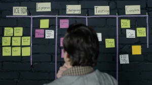 person viewing a project board covered with sticky notes